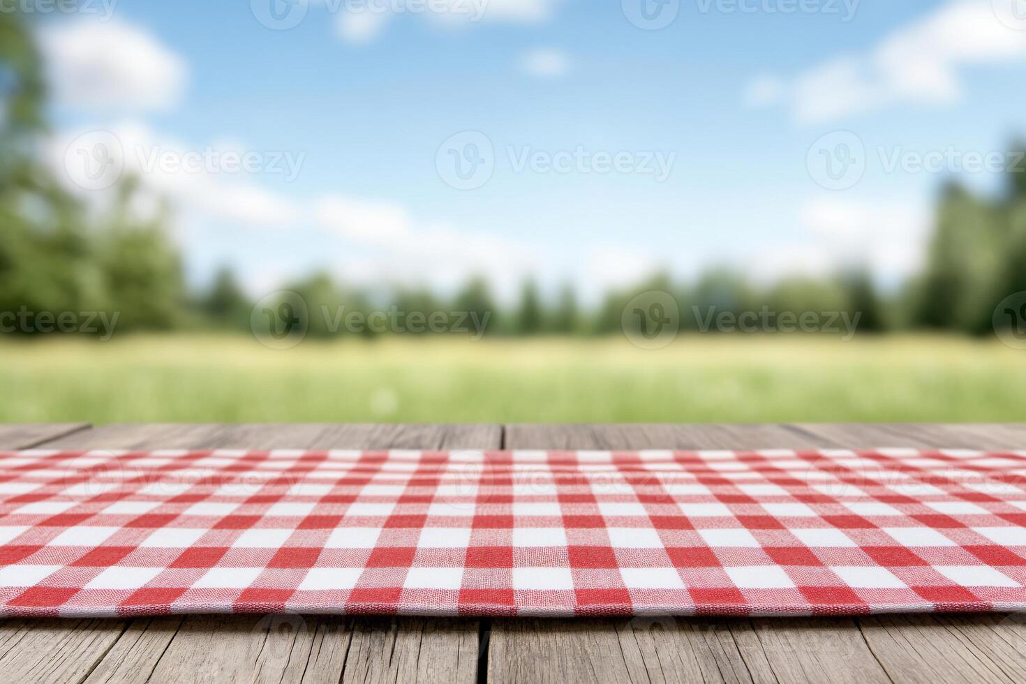 A picnic tablecloth on a wooden surface with a blurred outdoor background. photo