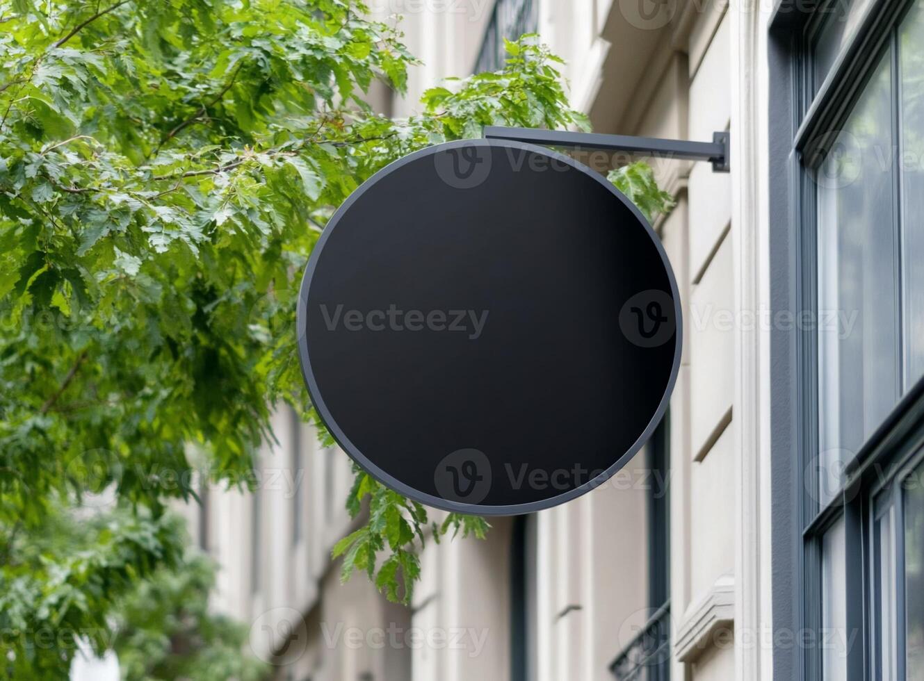 A blank circular sign mounted on a building, surrounded by greenery. photo