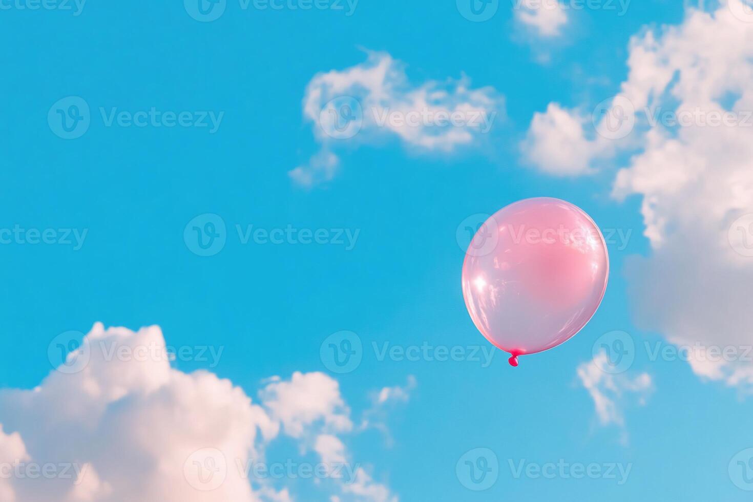 A pink balloon floating in the sky photo