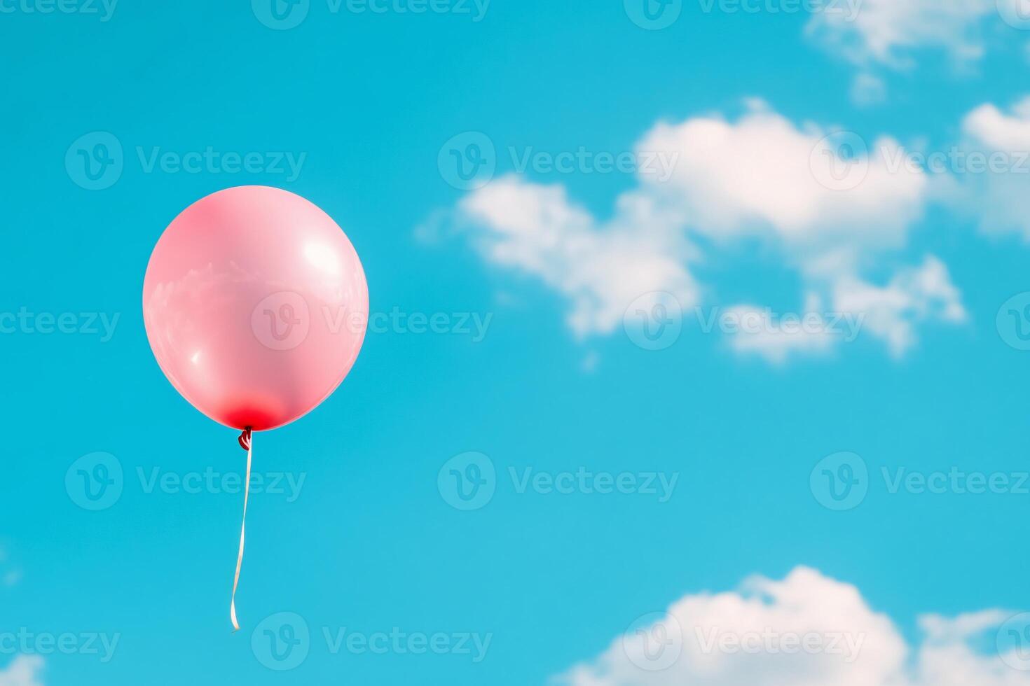 A pink balloon floating in the blue sky photo
