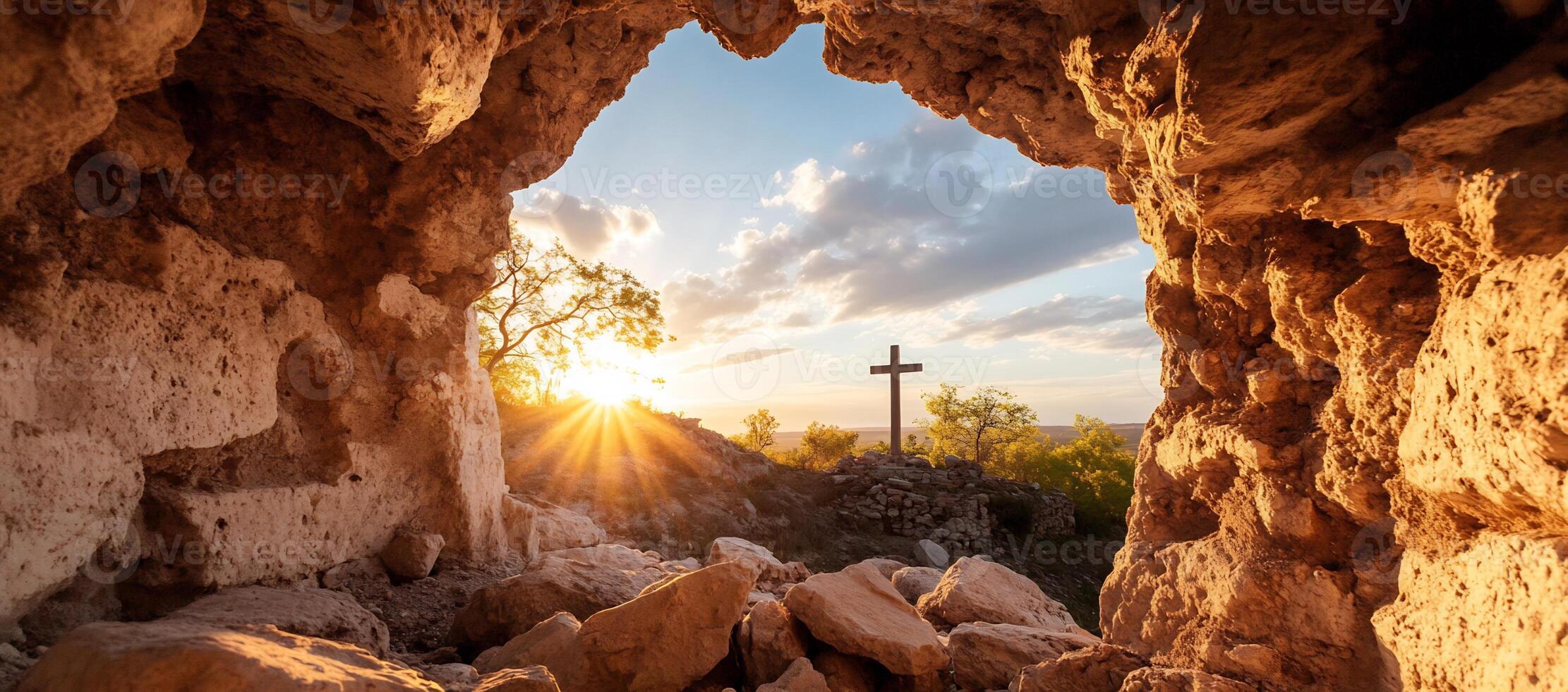 A serene view from a cave with a cross at sunset. photo