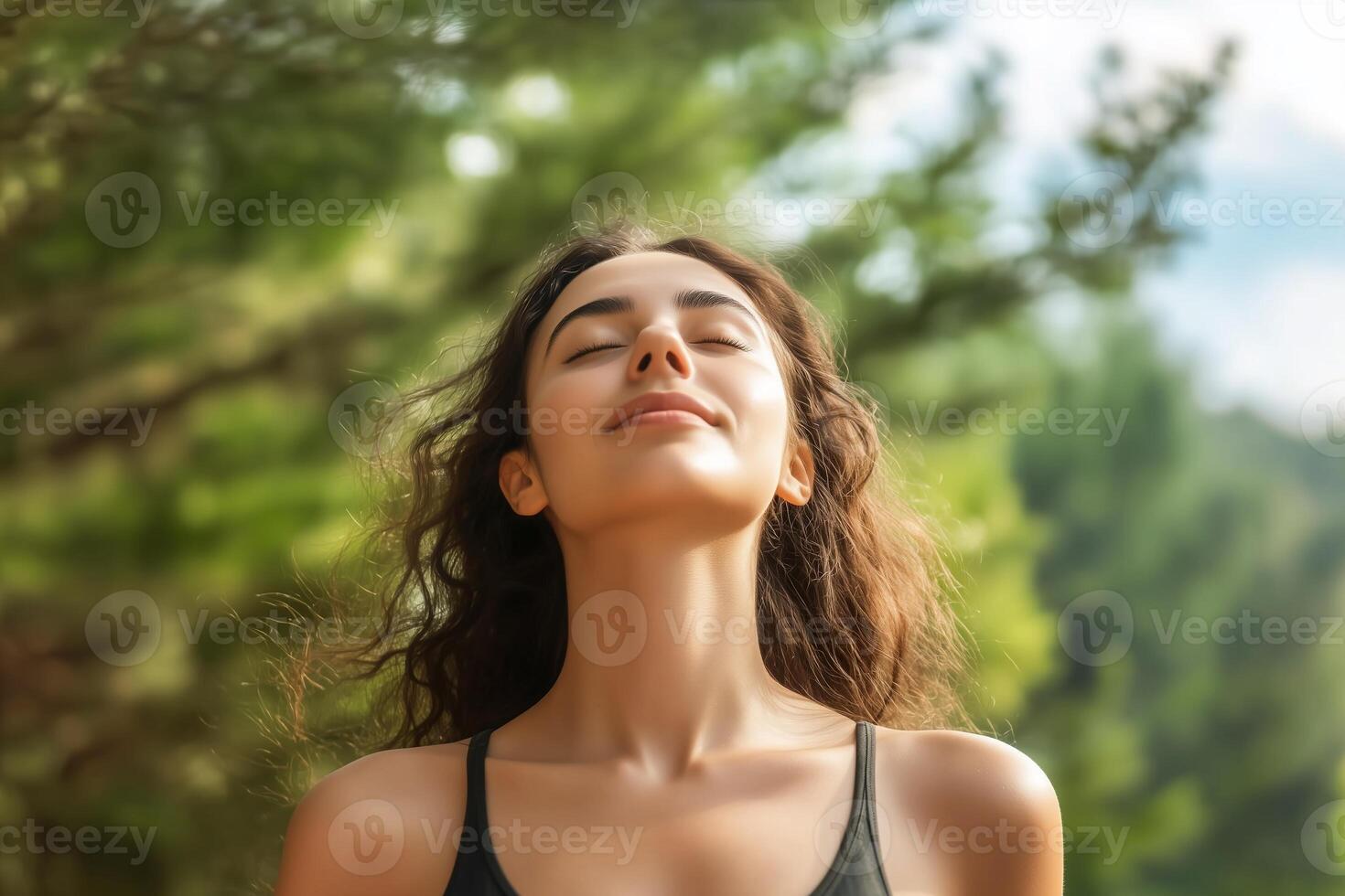 A serene woman enjoying nature with eyes closed in a lush environment. photo
