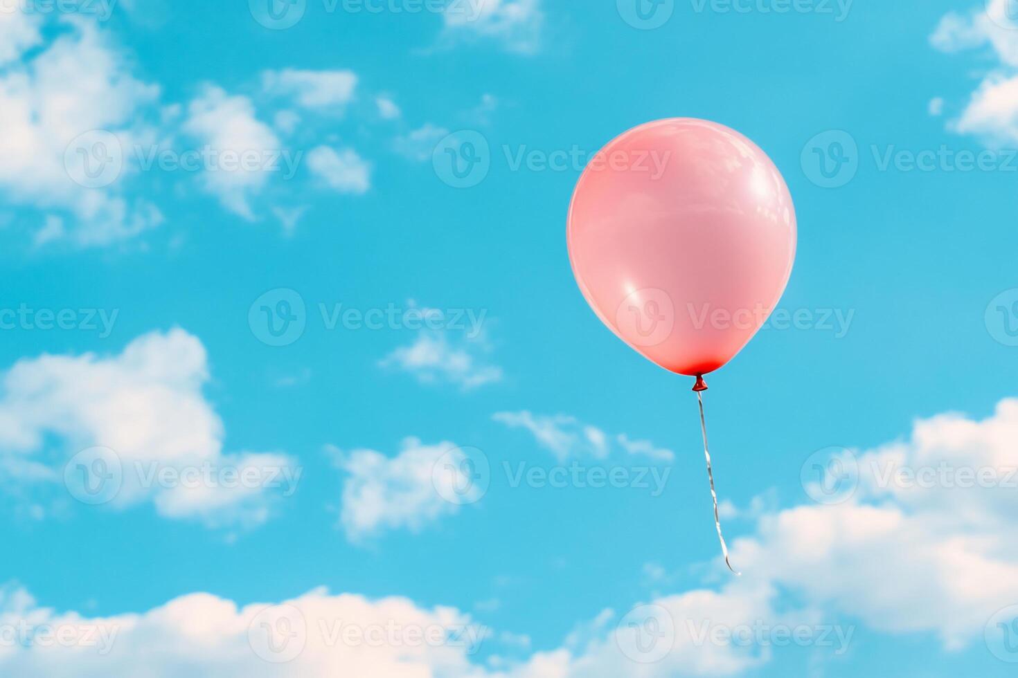 A pink balloon is floating in the sky photo