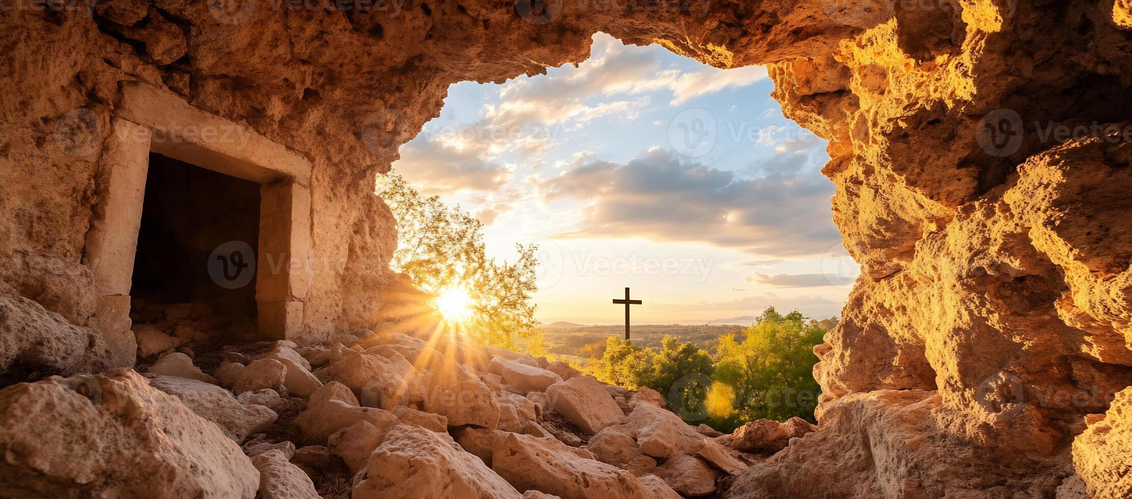 A sunrise view from a cave, with a cross in the distance. photo
