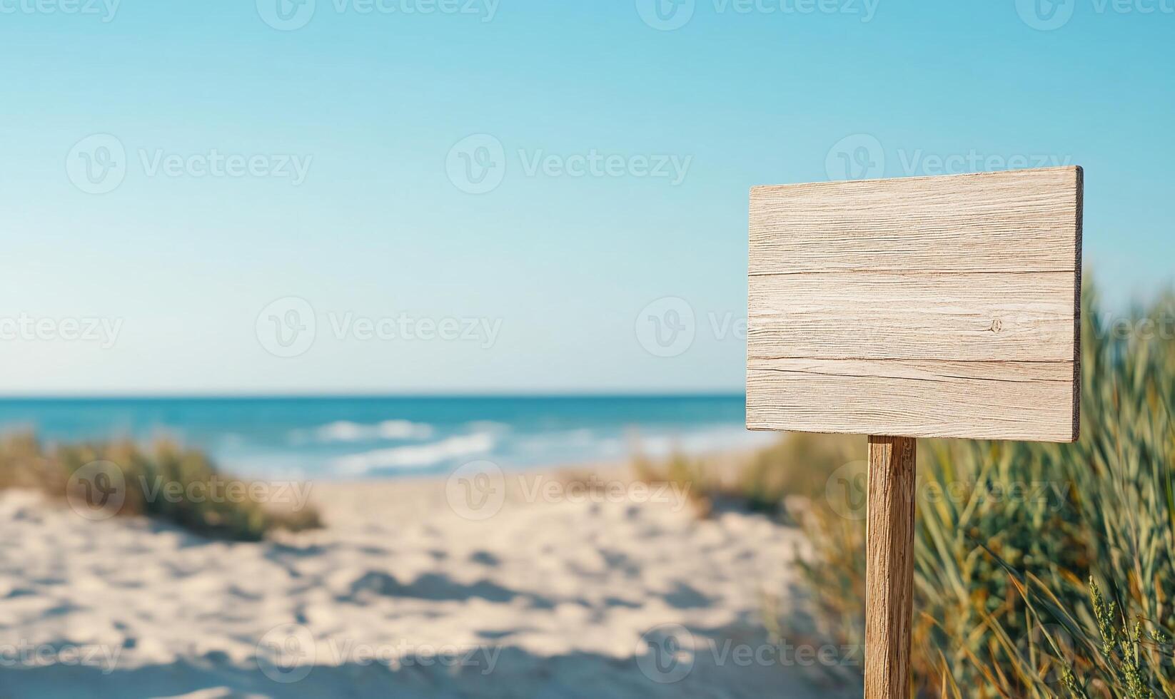 A wooden signpost on a sandy beach with ocean views. photo