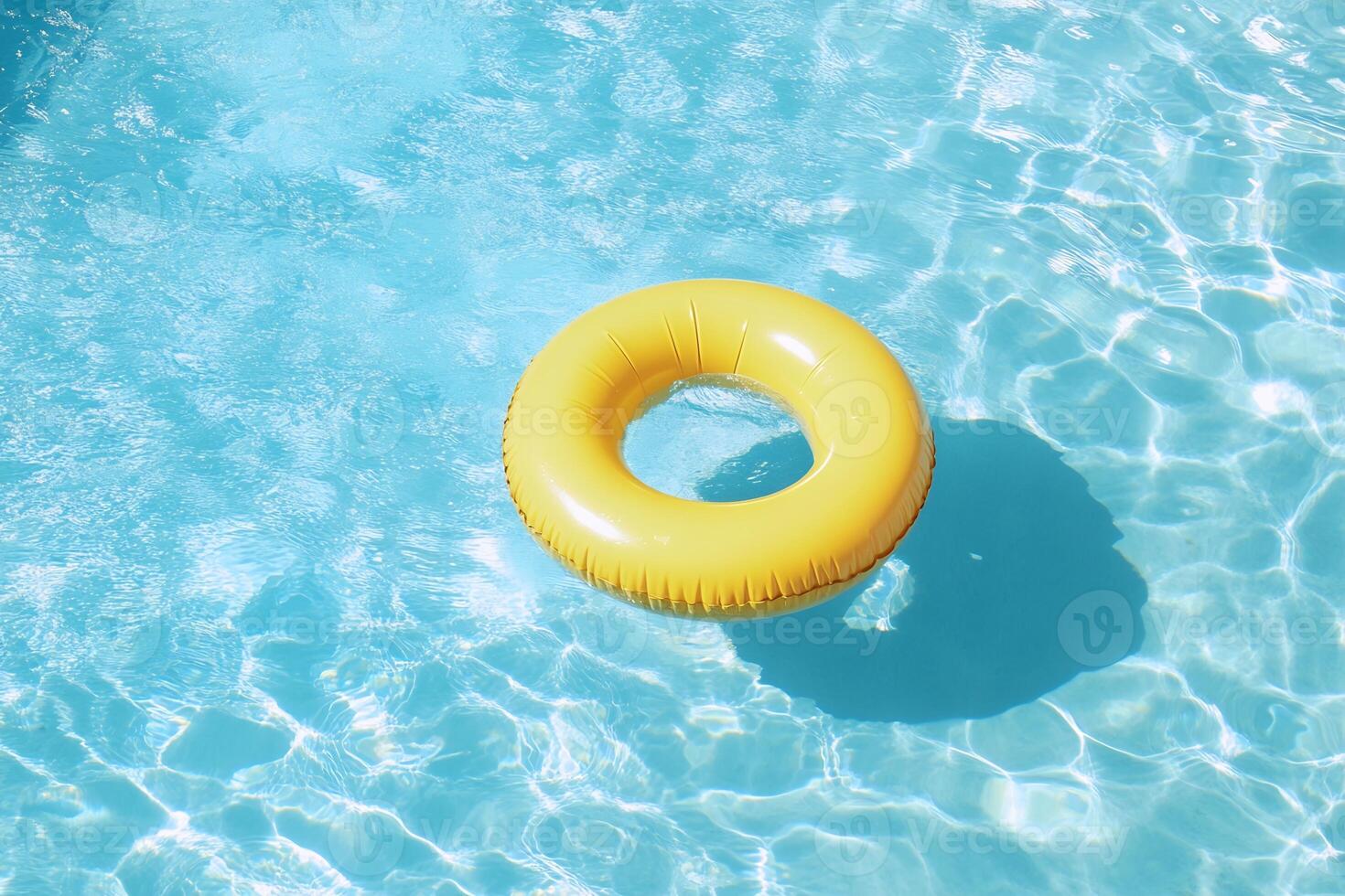 An inflatable yellow ring floating in a pool photo