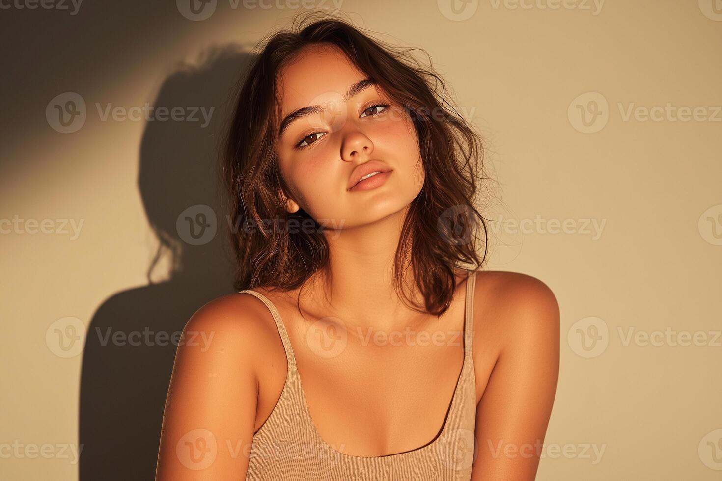 A woman in a tan top sitting on a chair photo