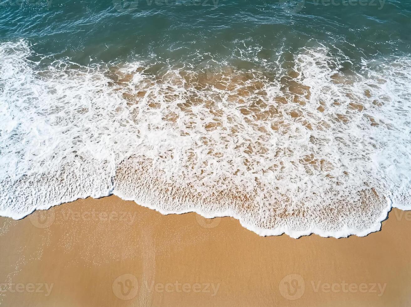 Aerial view of ocean waves lapping onto a sandy beach. photo