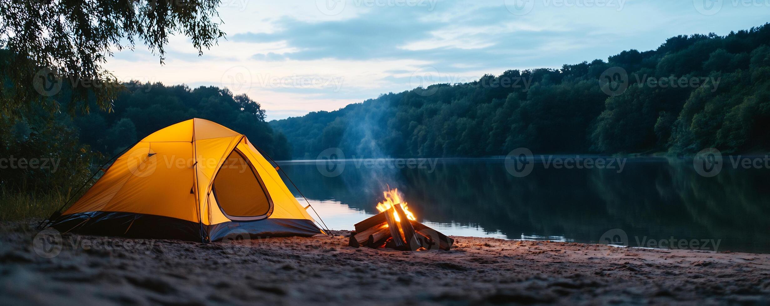 A tent is set up on the shore of a lake photo
