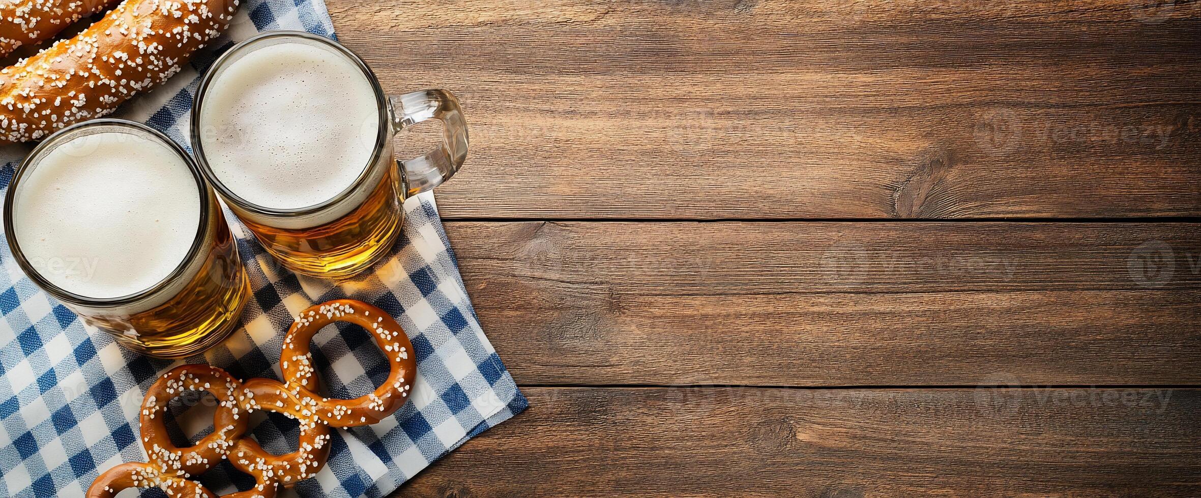 Two glasses of beer with pretzels on a checkered cloth. photo