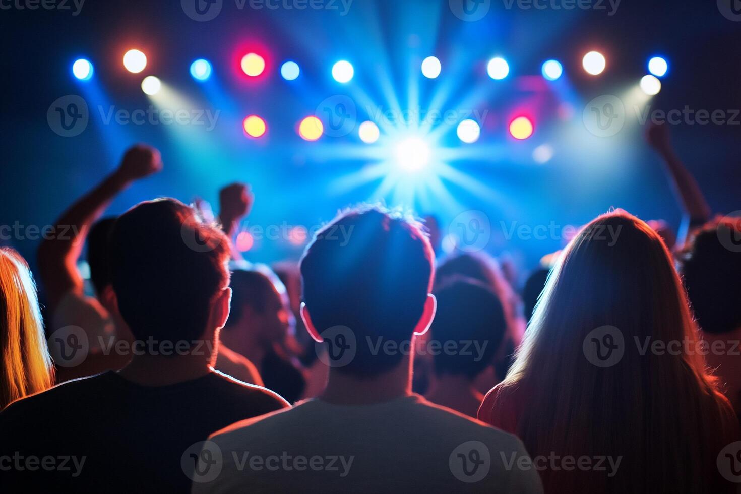 Audience enjoying a live performance with vibrant lights. photo