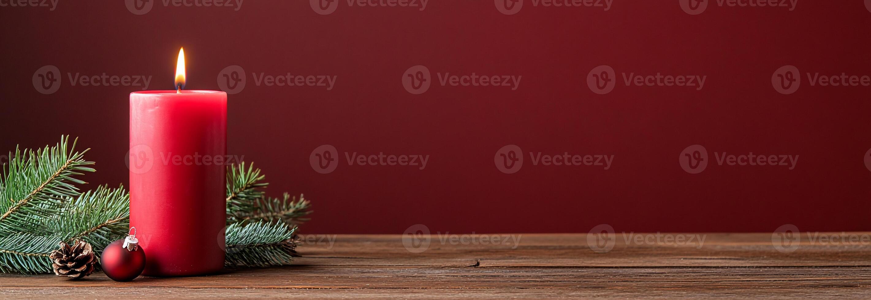 A festive red candle surrounded by pine branches and ornaments. photo