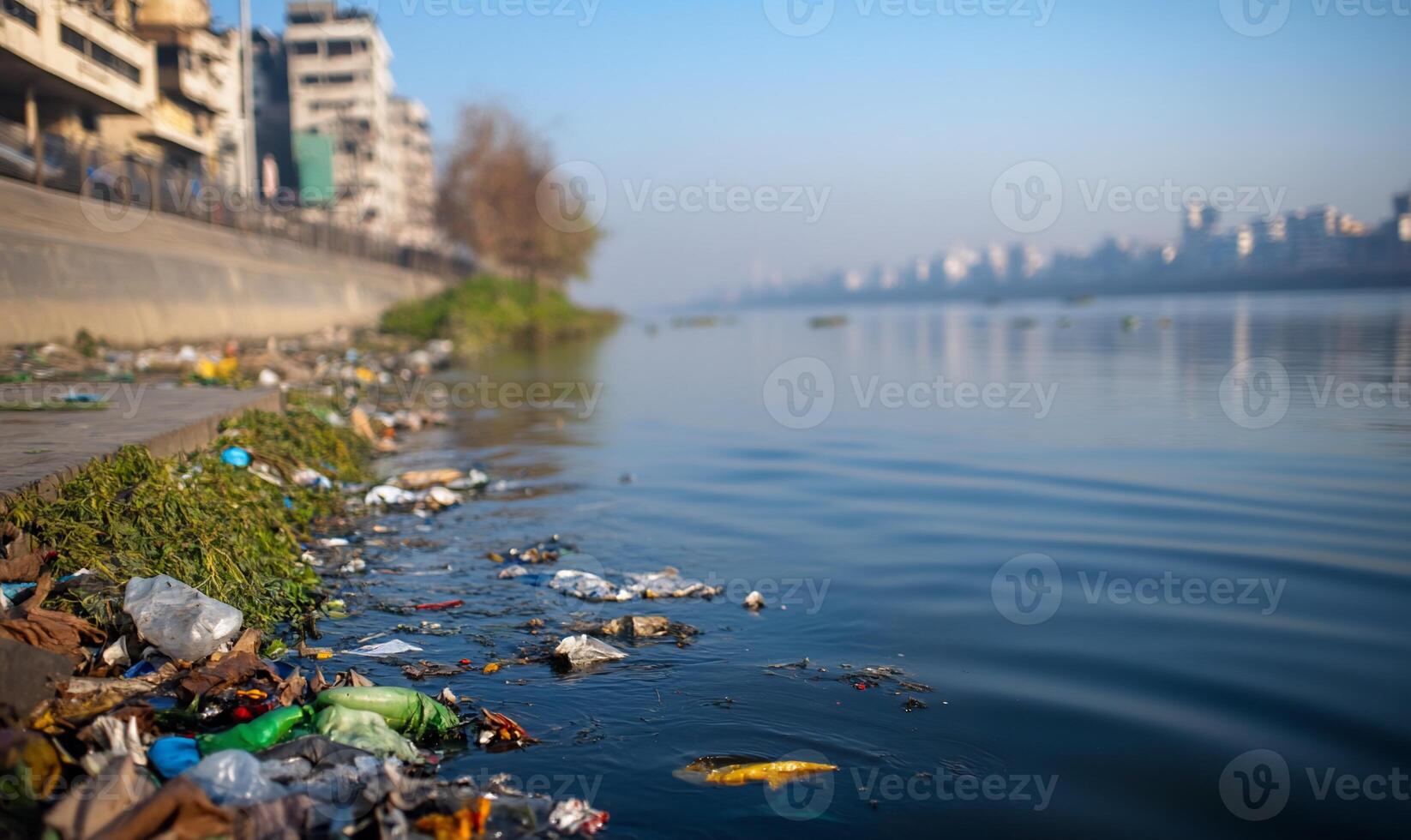 A polluted riverbank littered with trash and debris. photo