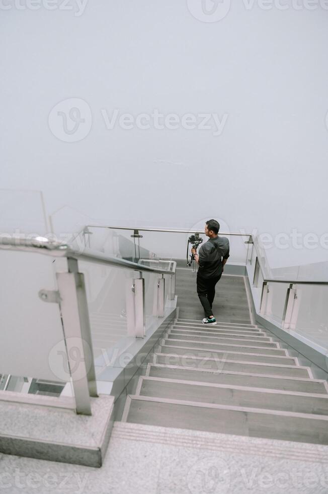 Photographer Ascending Stairs and camera gear in hand. photo
