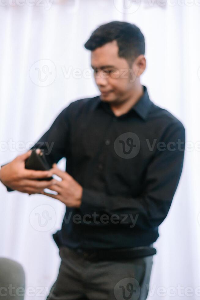 Focused man in shirt, engrossed in his mobile phone interaction photo