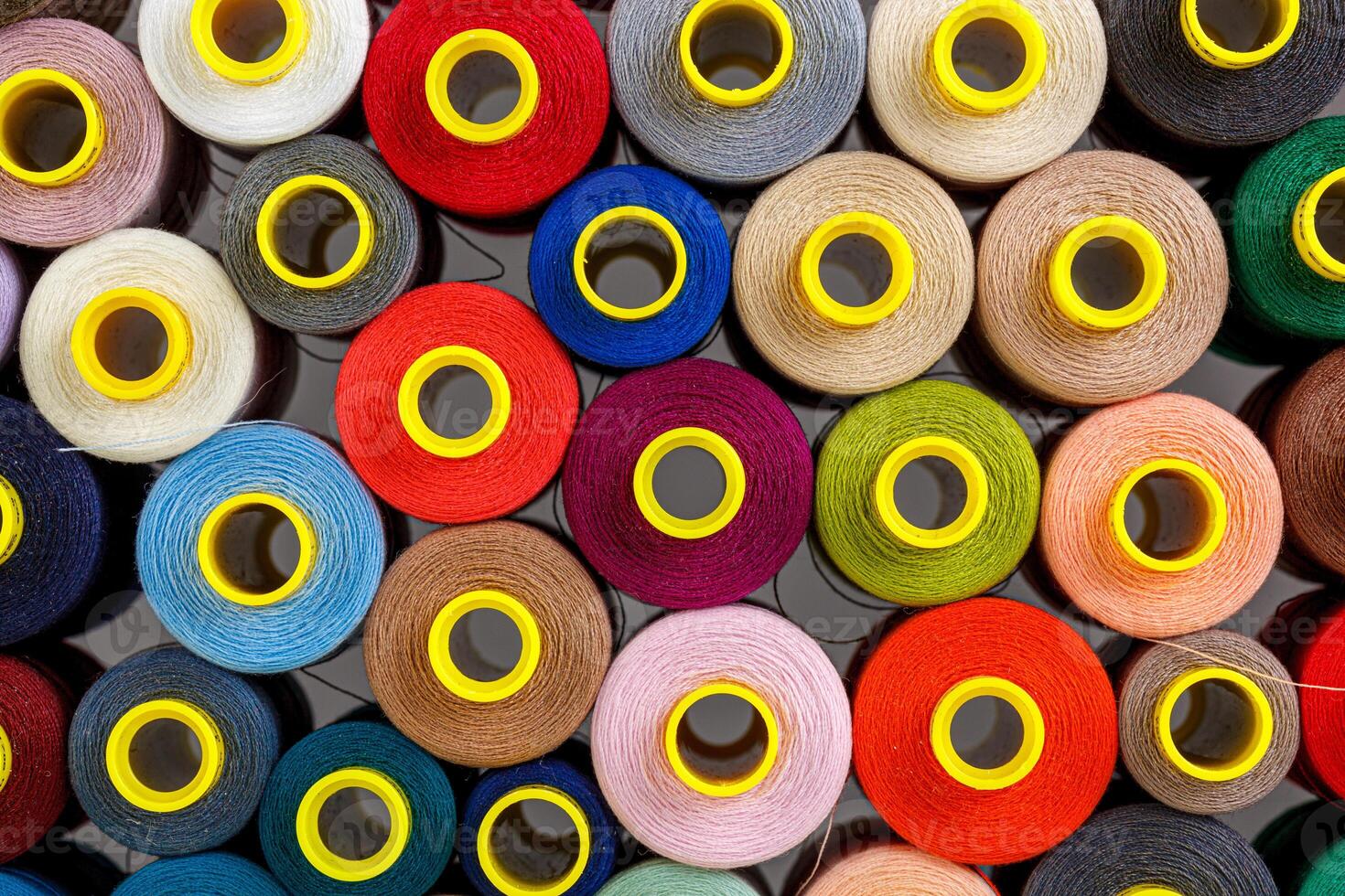 close up set of multi-colored spools of thread for sewing photo
