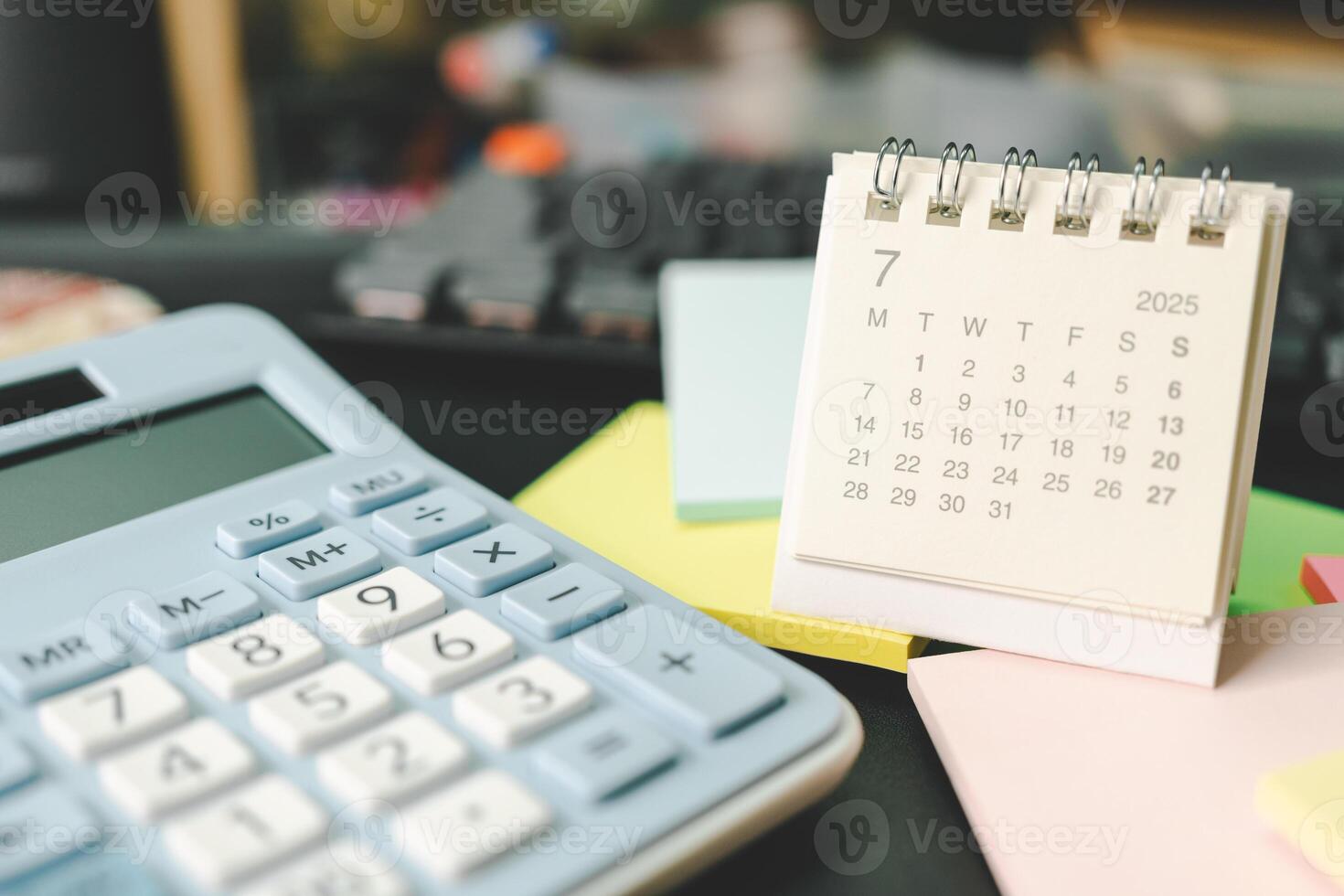 Desk calendar for JULY 2025 with Sticky note. Calendar concept with 2025 JUL calendar. calculator and forecast for finances in 2025. Money, Budget, tax, investment and financial. photo