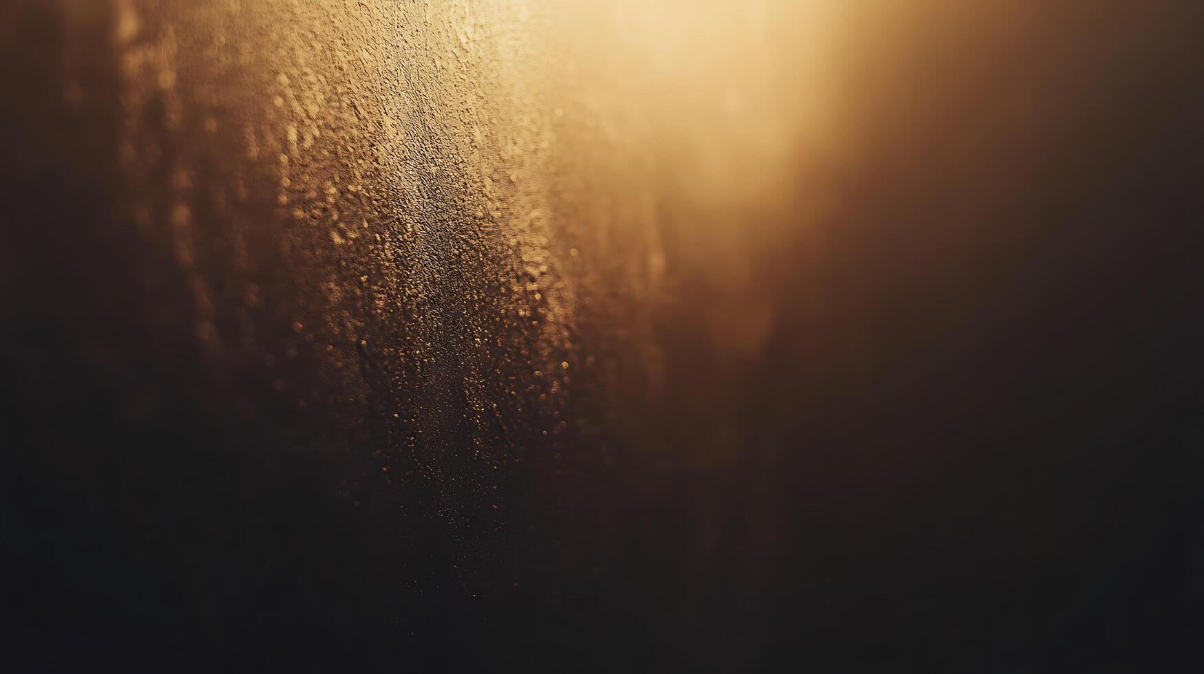 Textured surface with a golden sheen. A rustic wall with texture fades into the darkness, highlighting the granular structure and golden light. photo