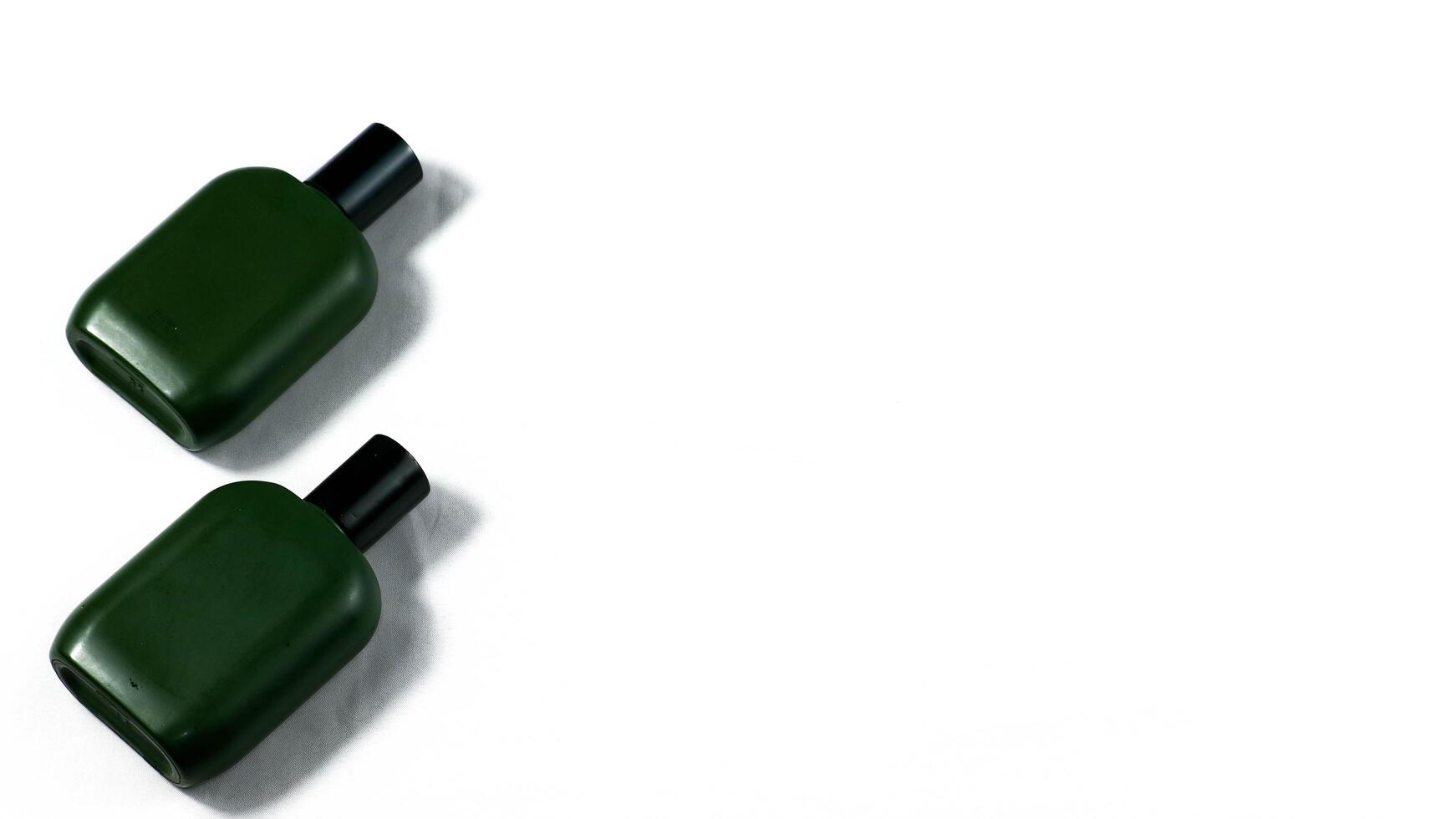 two green bottles sitting on top of each other isolated on white background photo