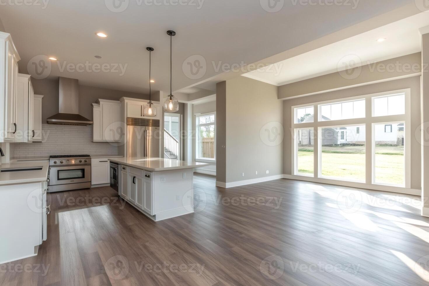 Modern open plan kitchen and dining area with large windows providing natural light photo