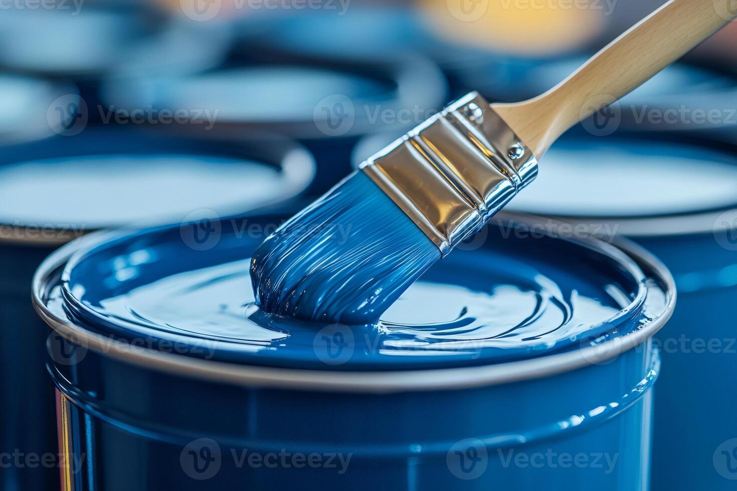 Paint brush dipping in blue paint can creating vibrant swirls photo