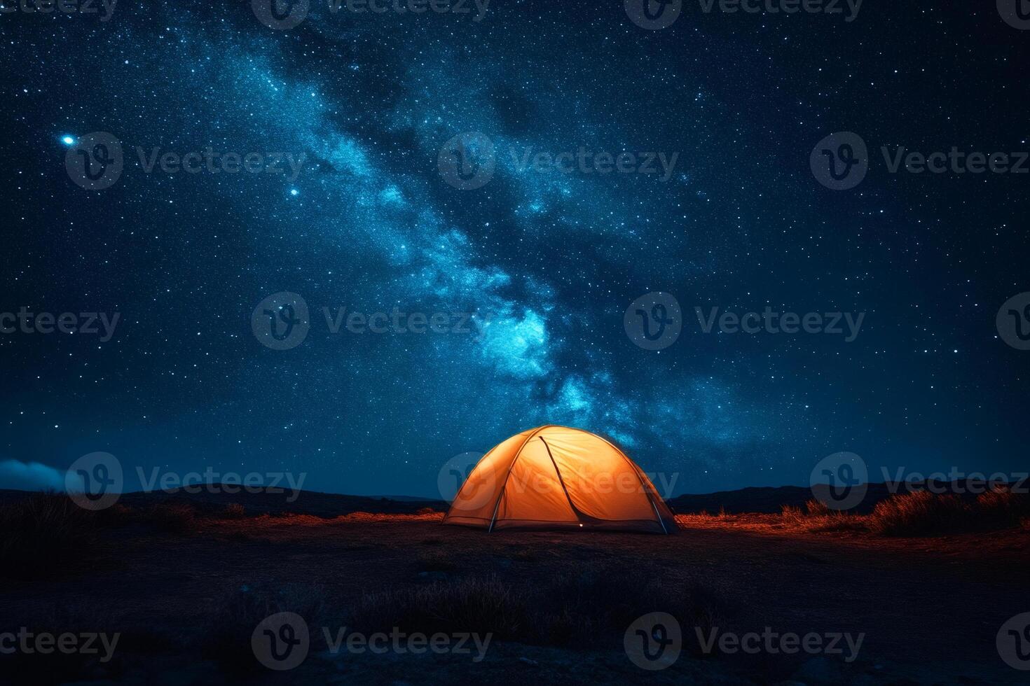 Illuminated tent camping under a breathtaking milky way galaxy photo