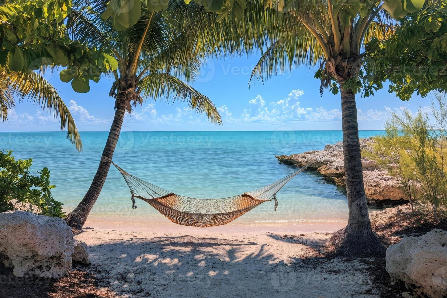 Hammock hanging between two palm trees on tropical beach photo