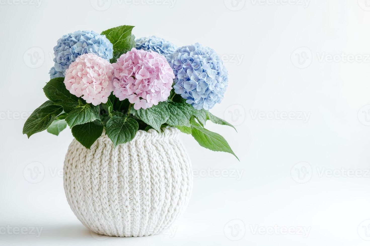 A bouquet of hydrangeas in a knitted white vase, adding a touch of elegance to decor photo