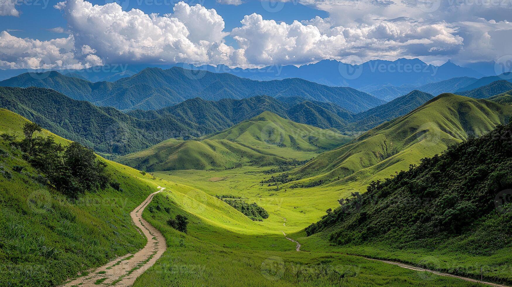 Scenic Winding Dirt Road Through Lush Green Mountains and Valley Landscape under a Blue Sky with Fluffy White Clouds photo