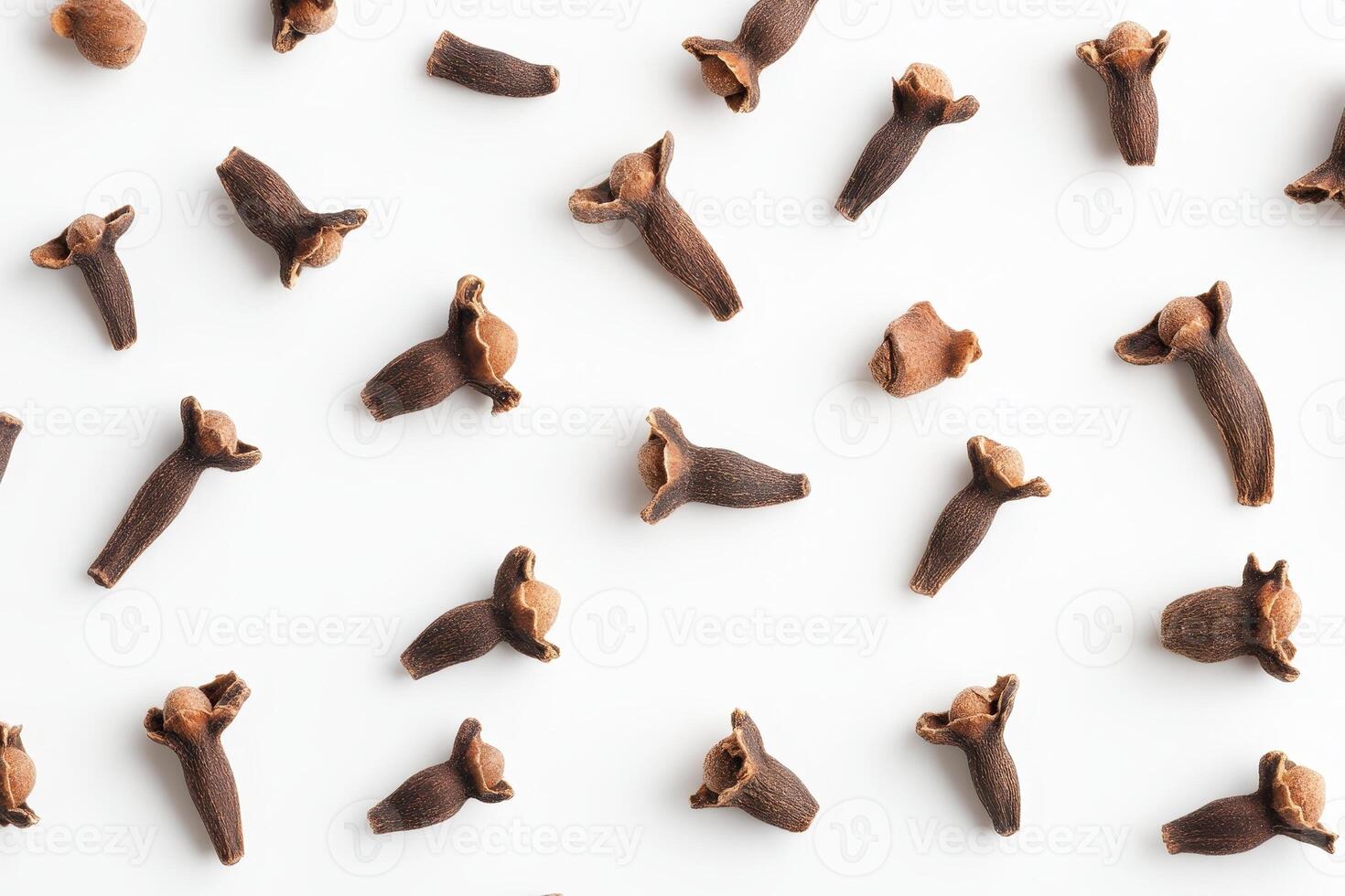 A collection of whole cloves scattered on a white background. photo