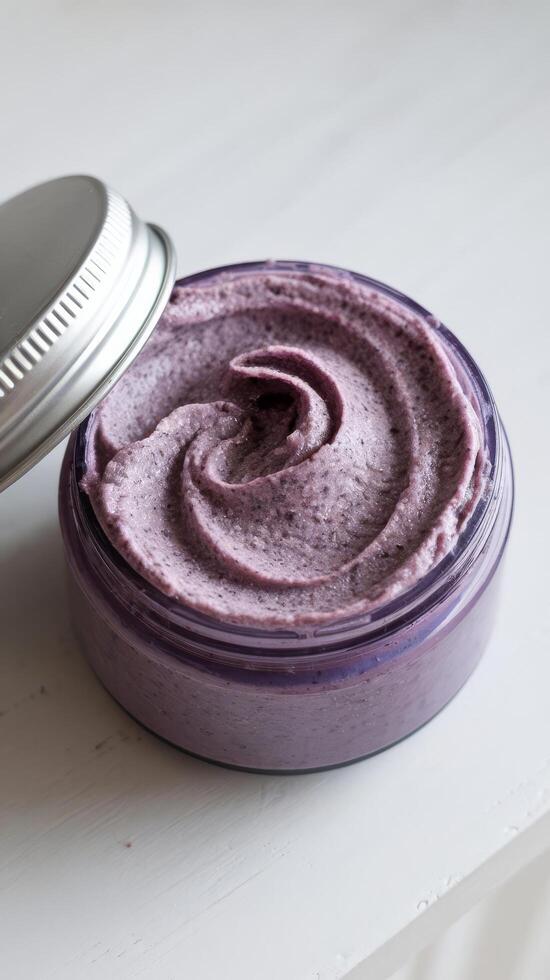 Purple cream scrub for washing an exfoliating skin care product isolated on a white background photo
