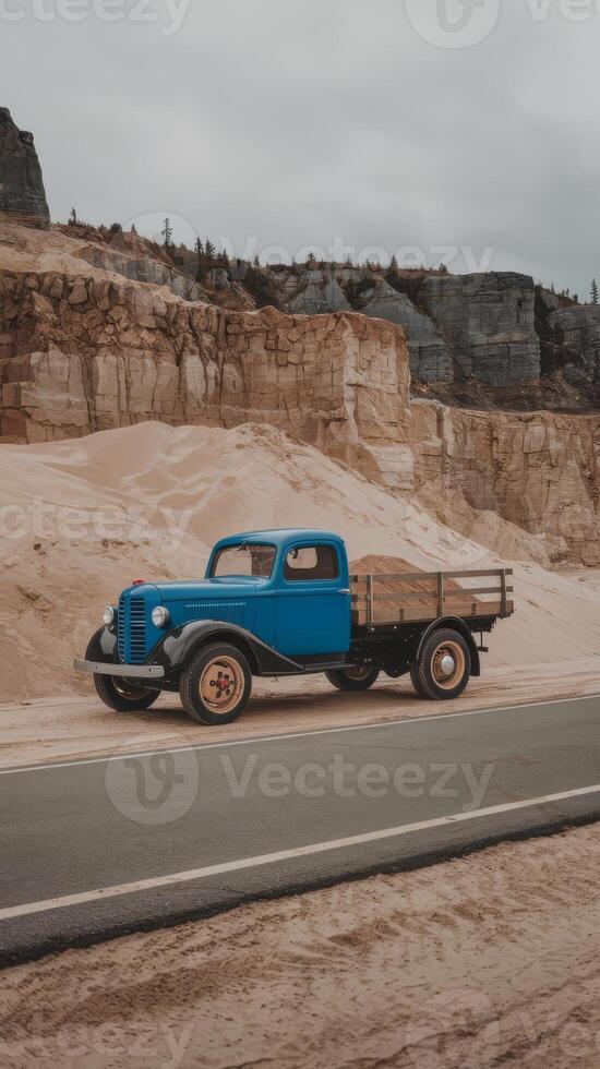 An old blue truck driving down a road photo