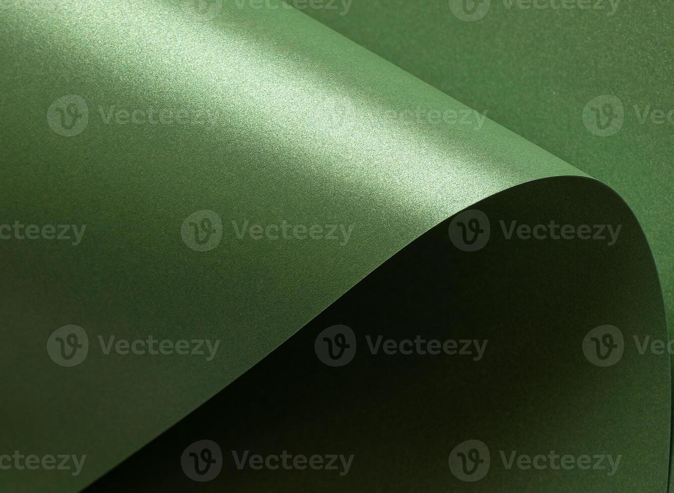 Emerald green paper background with a glossy, satin texture and shimmering wavy edges. Deep forest photo