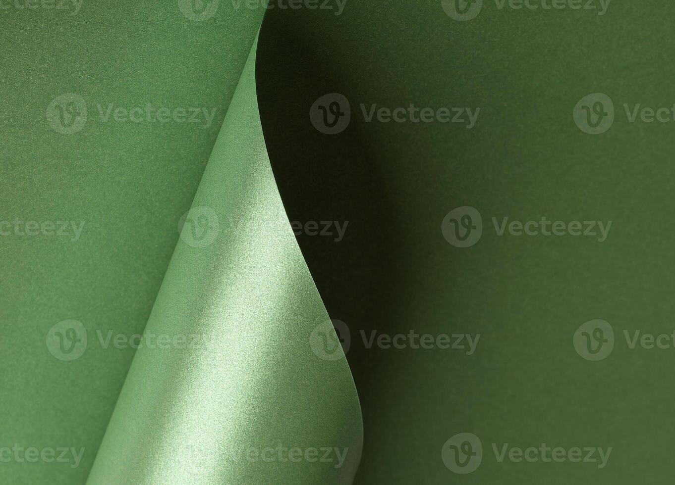 Emerald green paper background with a pearlescent, shimmering wavy edges. Deep forest and sage tones photo