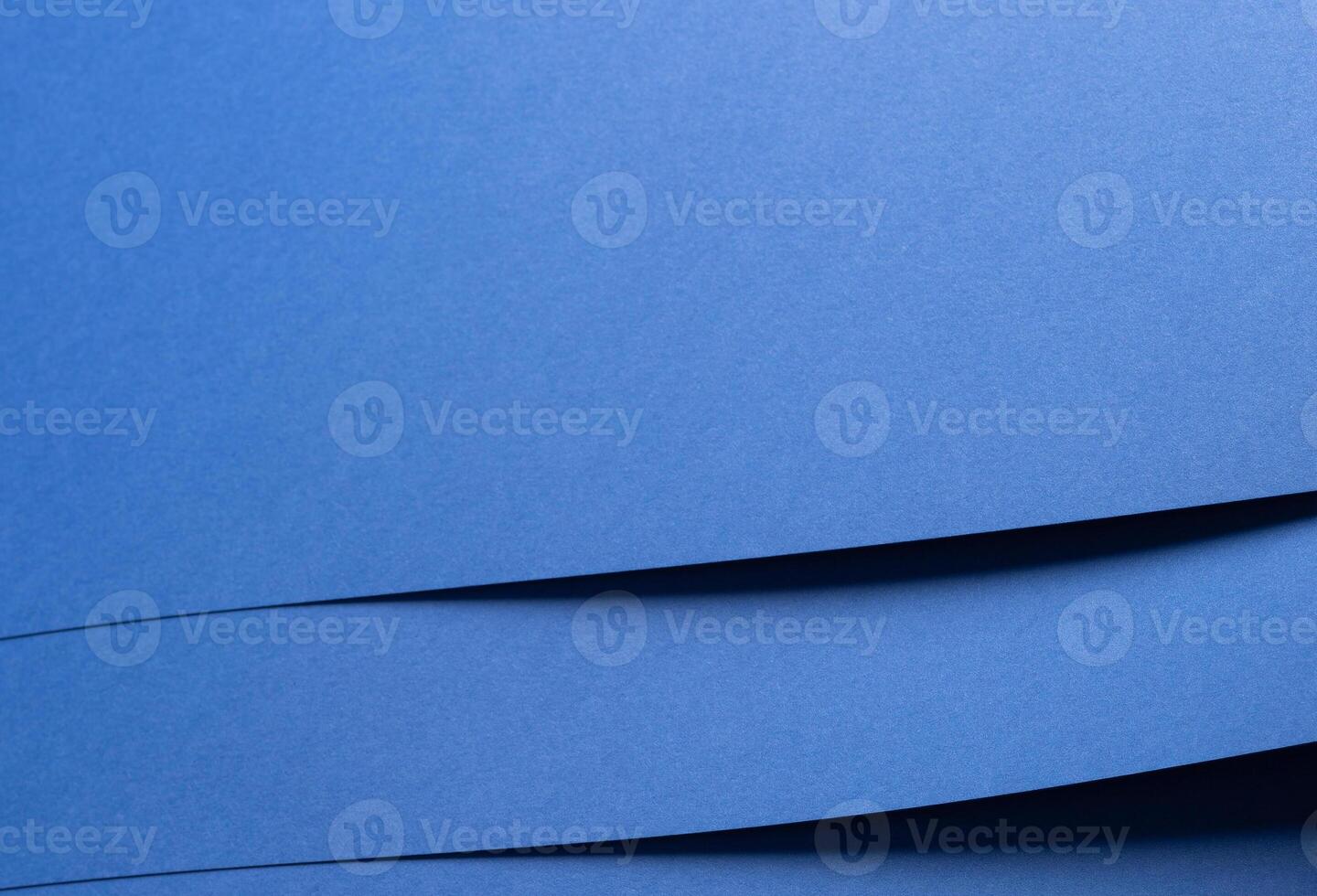 Deep sapphire blue paper background with smooth texture and overlapping curved folds. Vibrant cobalt photo