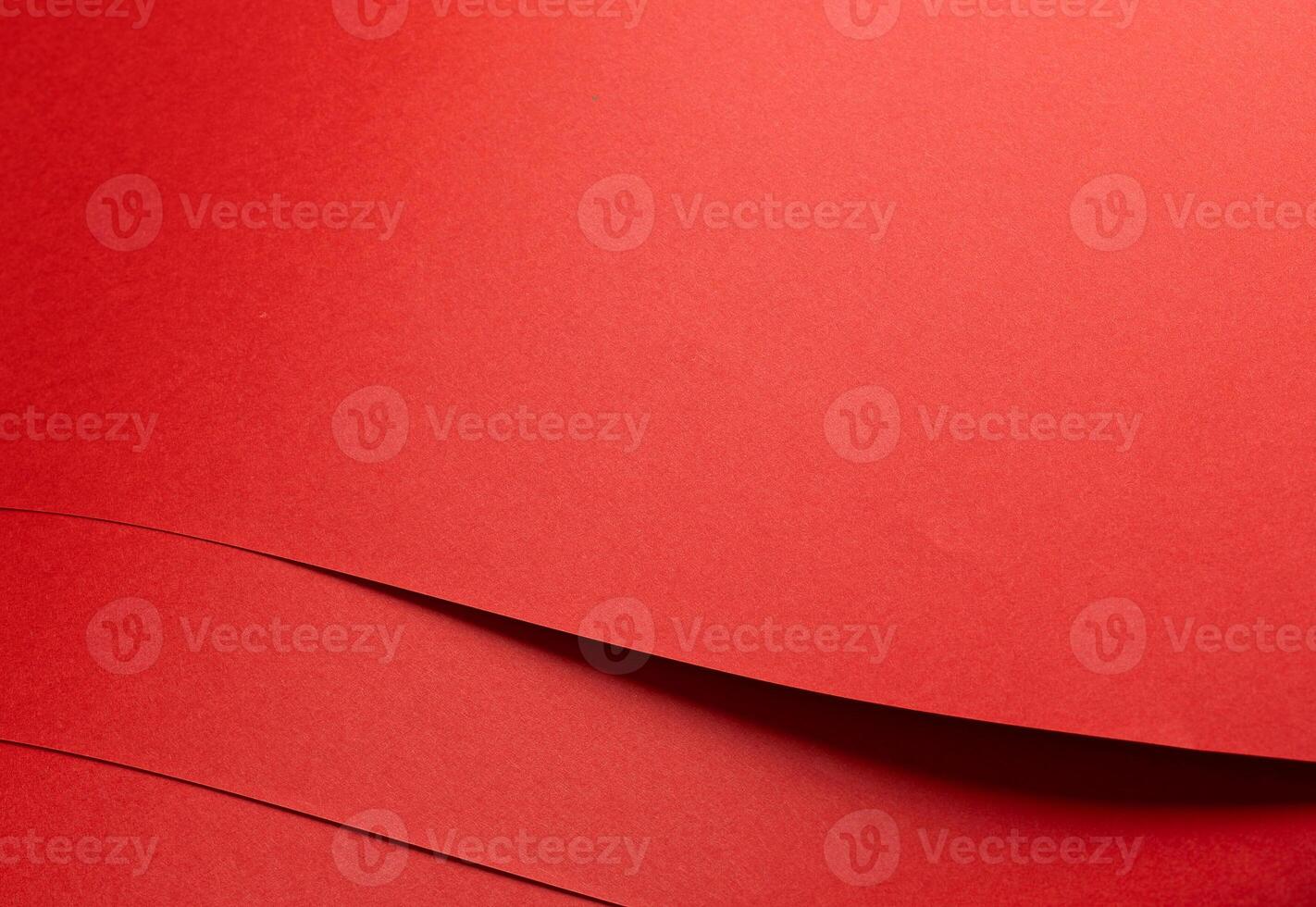 Fiery coral red paper background with a smooth texture and overlapping curved folds. Warm vermilion photo
