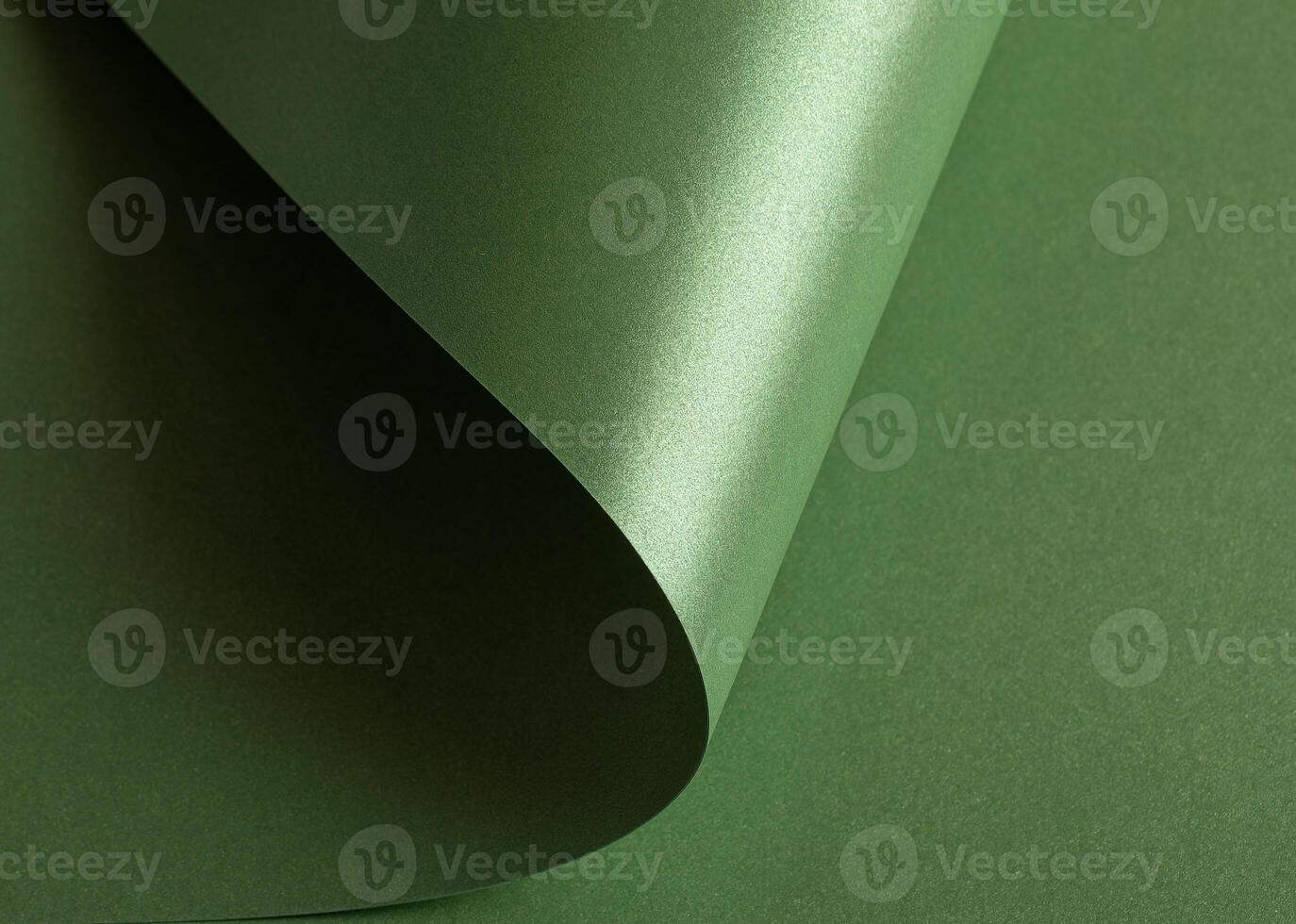 green paper background with a pearlescent, glossy texture and shimmering wavy edges. Deep forest and photo