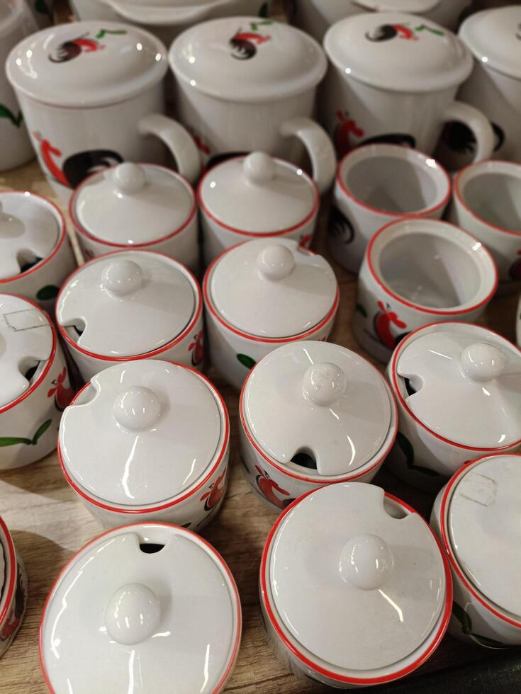 A number of ceramic mugs are arranged in a row on the table photo