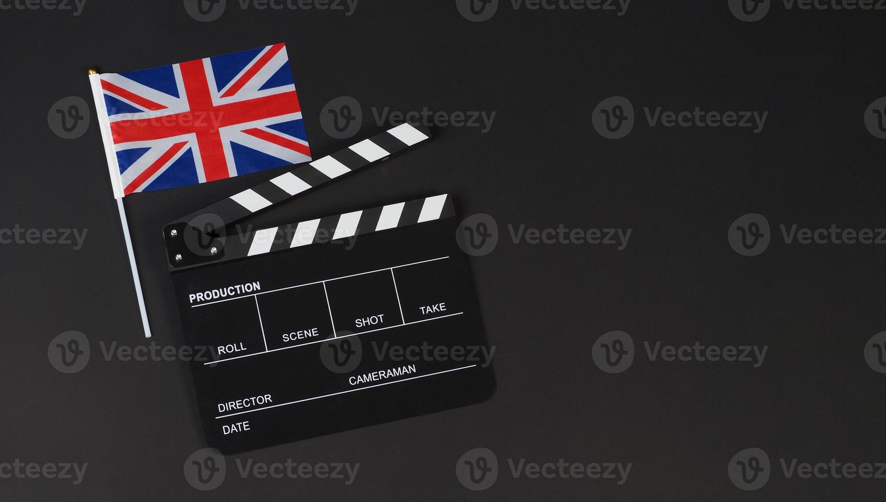 Union Jack flag and clapper board on black background. photo