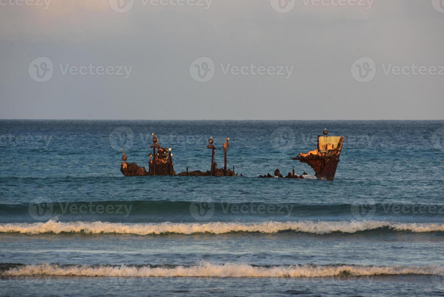 Sun Rising Over a Rusty Wreck of a Shipwreck photo