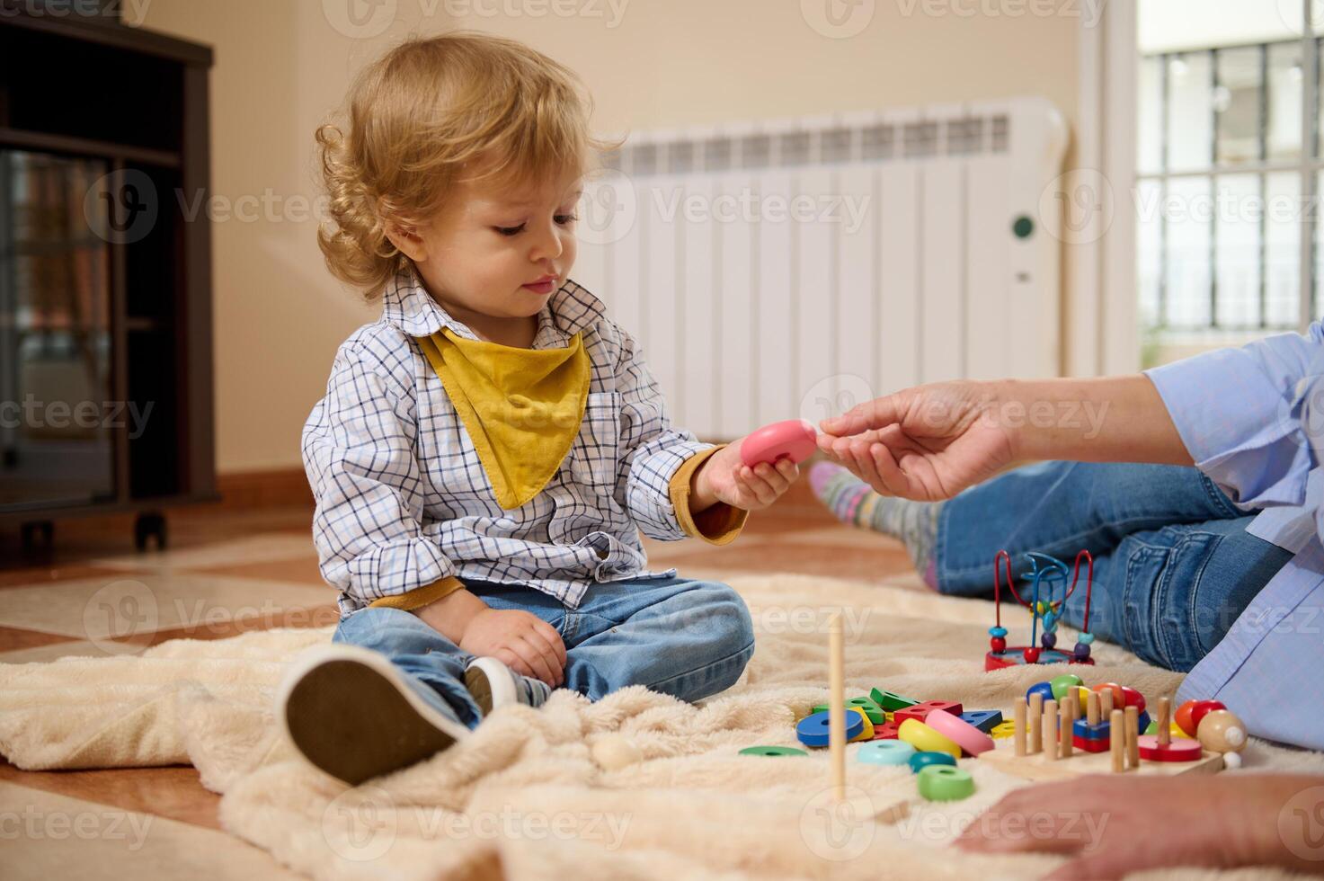 Toddler Sitting on Floor Playing with Colorful Toys in a Cozy Home Setting photo