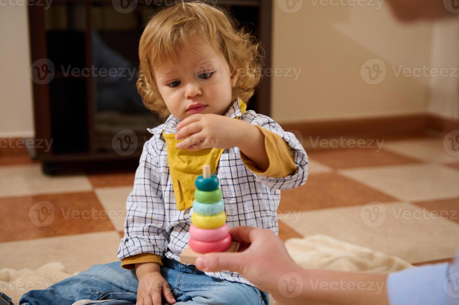 Young Child Engaged in Colorful Stacking Toy Activity at Home photo