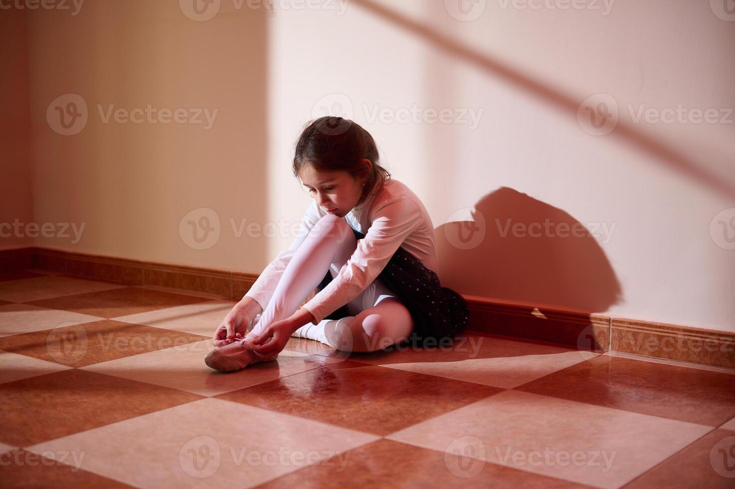 Young Ballet Dancer Preparing in a Sunlit Room photo