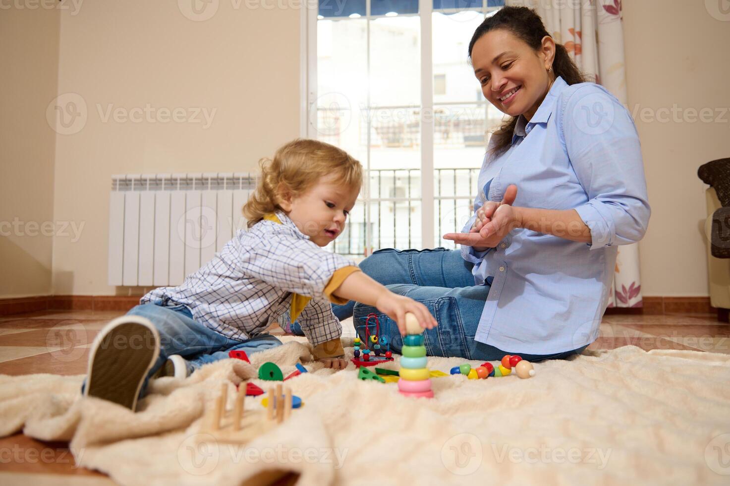 Mother Playing with Toddler on Floor While Engaged in Educational Toys photo