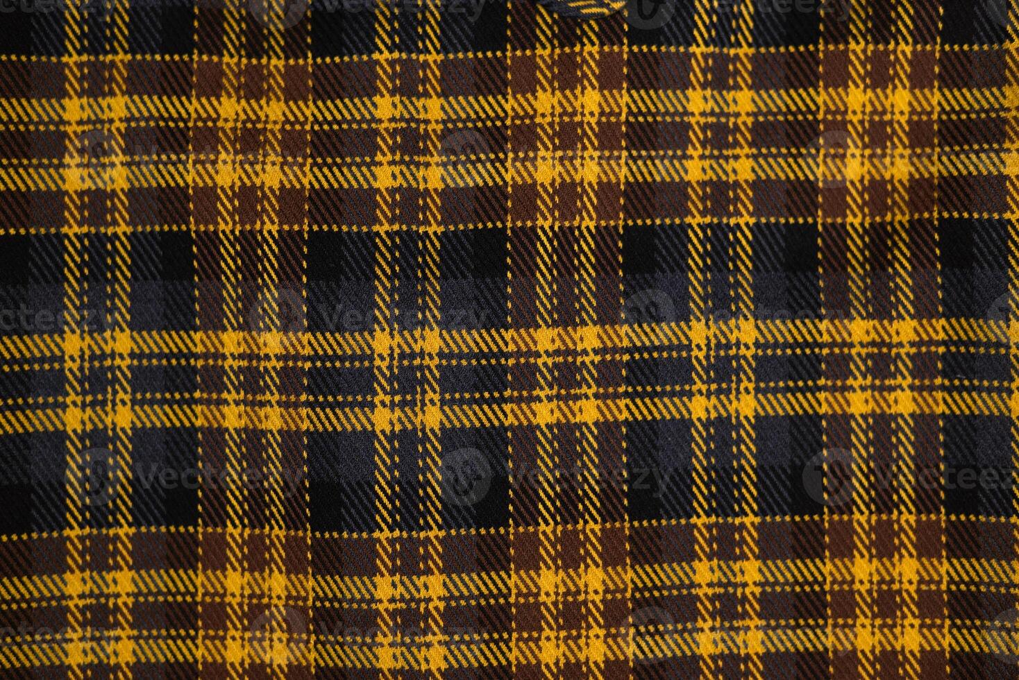 Close-up of a yellow and black plaid fabric texture.Classic checkered textile pattern, warm flannel material for fashion photo