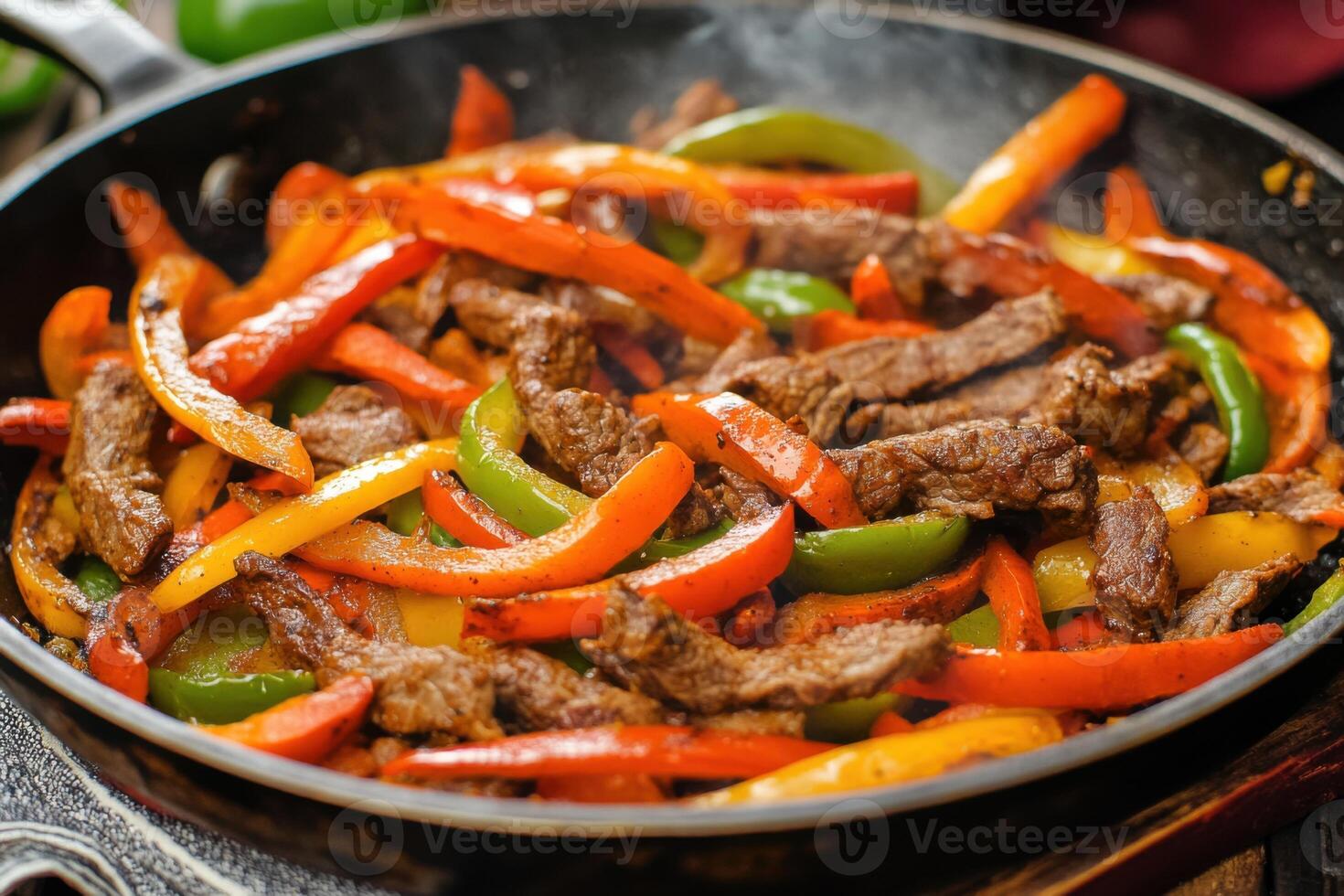 A colorful platter of sizzling beef fajitas with vibrant bell peppers, served in a skillet. photo