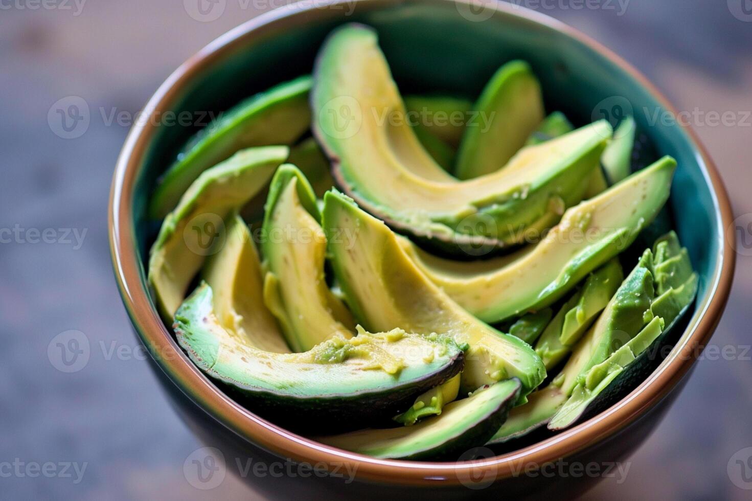 Fresh avocado slices in a bowl, ready to eat. Healthy vegan food, organic ingredient for salads, toast, and guacamole. photo