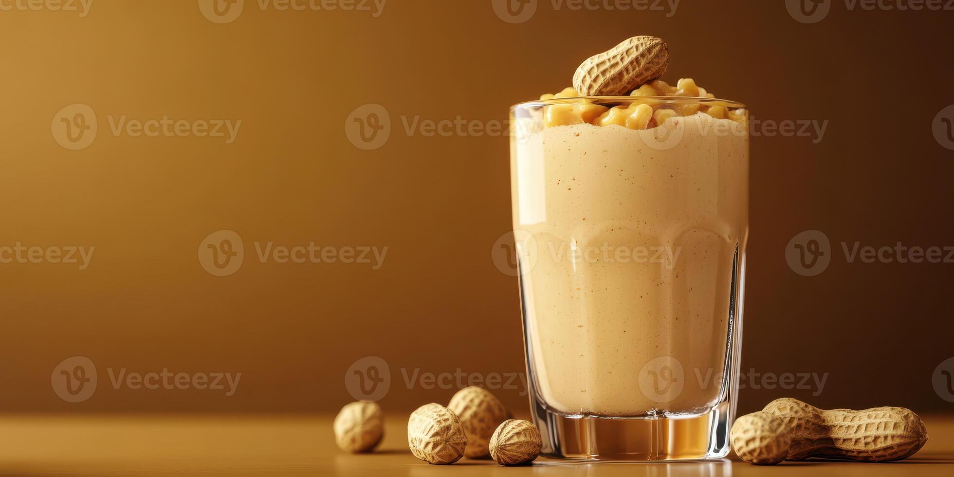 Creamy peanut butter smoothie served in a glass with peanuts scattered on the table photo