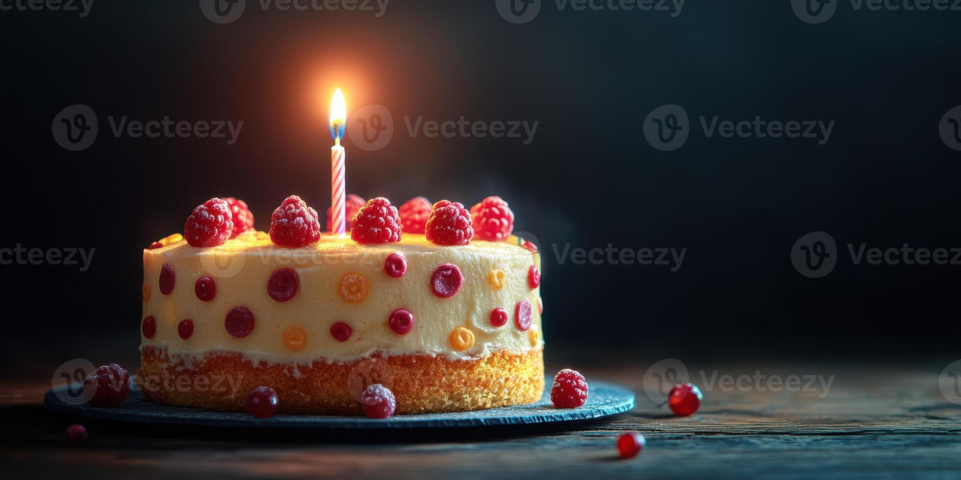 Delicious round cake topped with fresh raspberries and a lit candle placed on a dark wooden table in a cozy setting photo