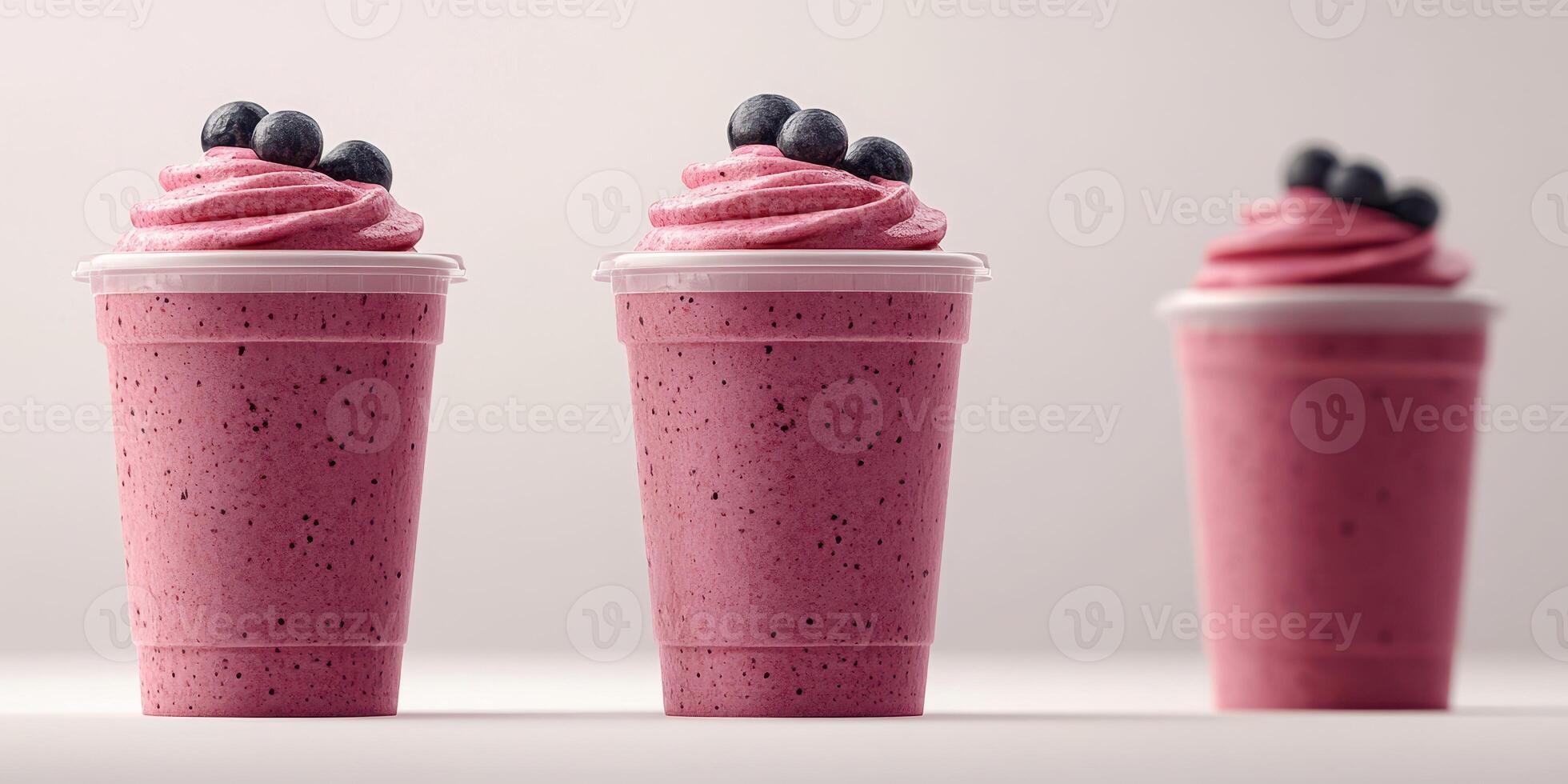 Bright pink berry smoothie cups with whipped cream and blueberries displayed on a simple background photo